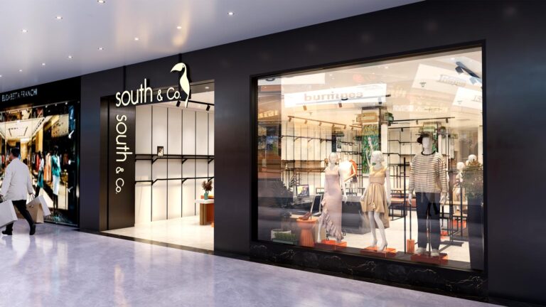 Wide view of clothing store center area with custom display tables and apparel display stands