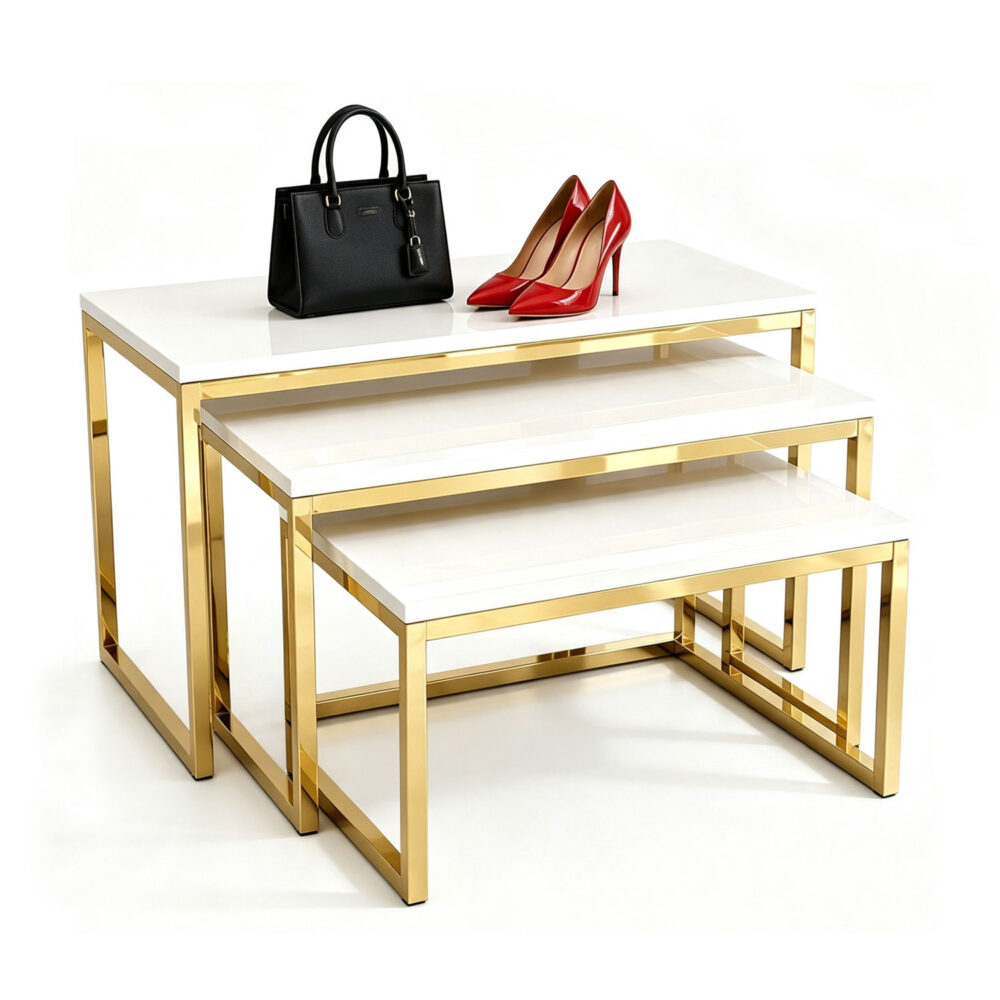 Set of 3 titanium gold stainless steel nesting retail display tables with white tops, isolated on pure white background.