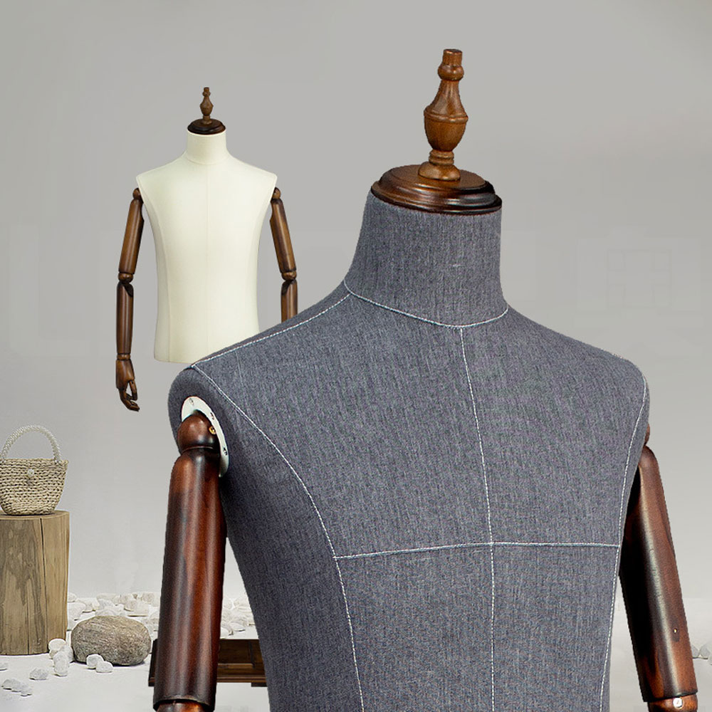 Detailed stitching and dark wood articulated arm joint of grey fabric male tailor mannequin